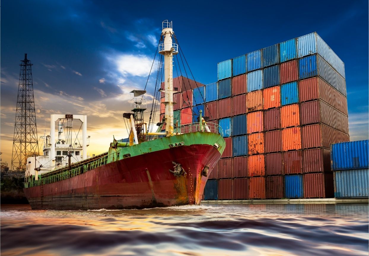 Buque de carga y contenedores en un puerto, comercio internacional e Incoterms